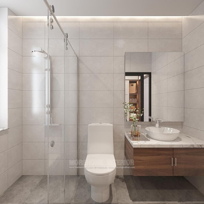 Thiết kế phòng tắm chung cư theo phong cách hiện đại đẹp với cách lựa chọn đồ vật tinh gọn nhưng lại tạo vẻ đẹp sang trọng cuốn hút từ tường ốp gạch giả bê tông, gương hiện đại không khung ốp tường, phòng tắm kính cửa trượt. Thiết kế chung cư
